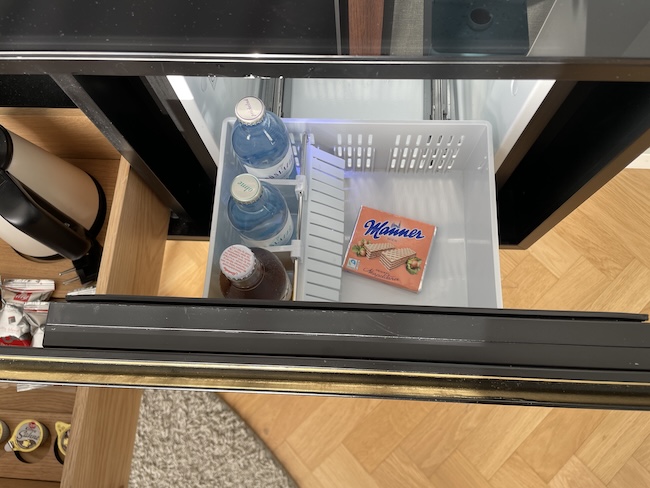 a refrigerator with a container of soda and a box of crackers