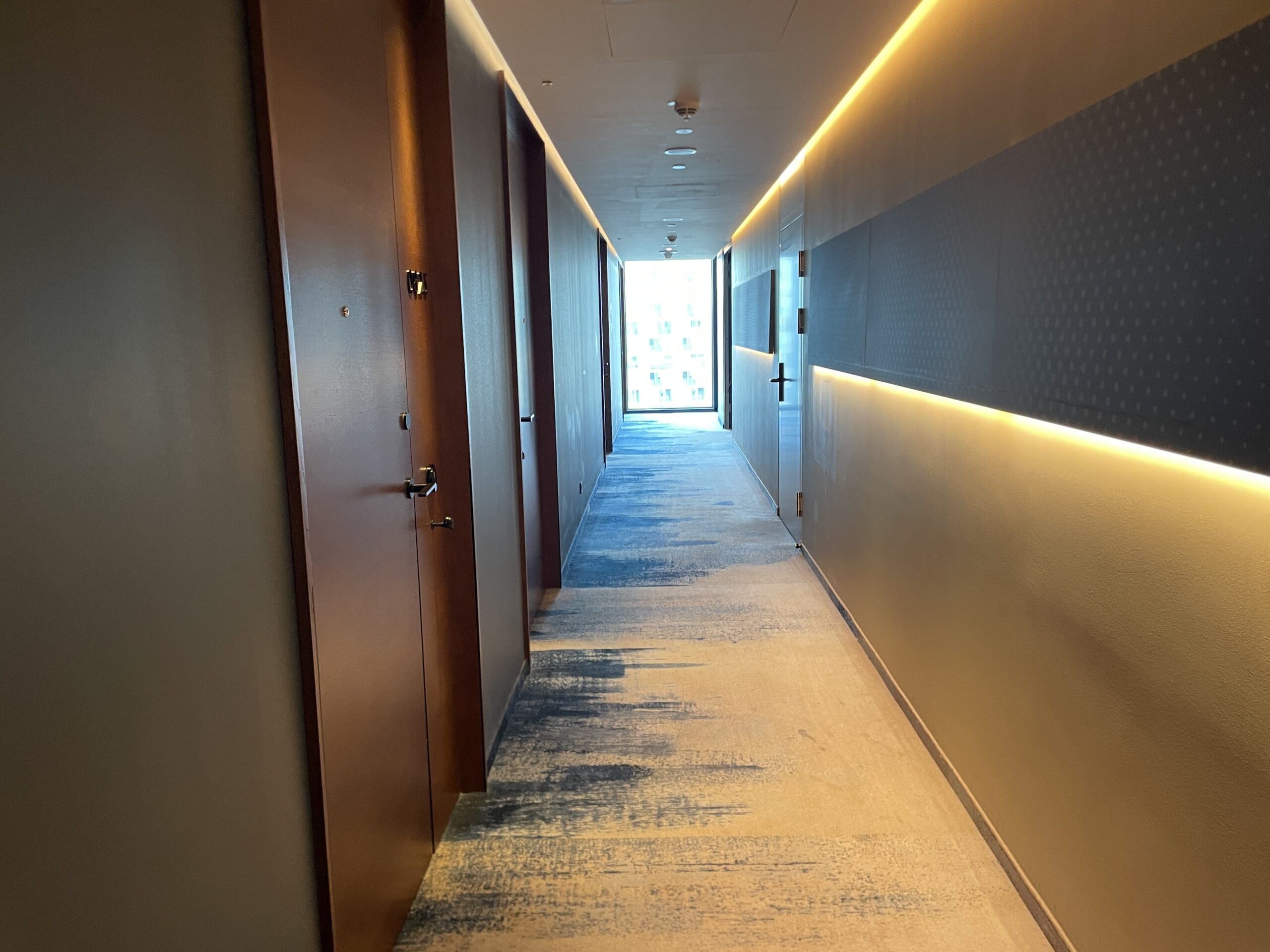 a hallway with doors and a light on the wall