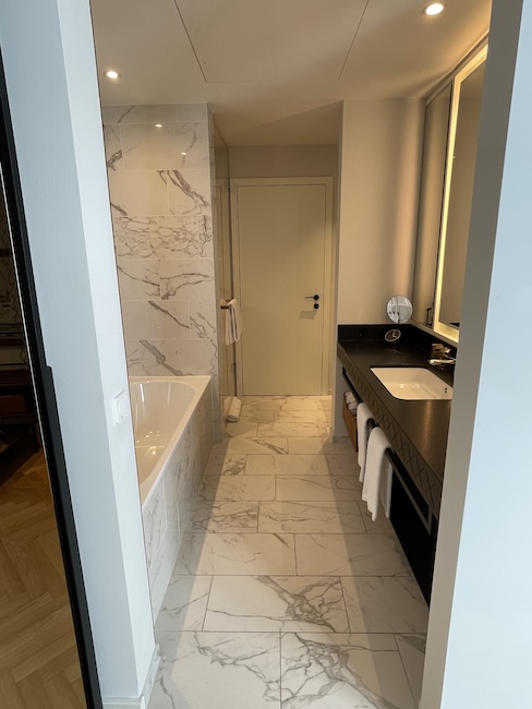 a bathroom with marble tile floor and a bathtub