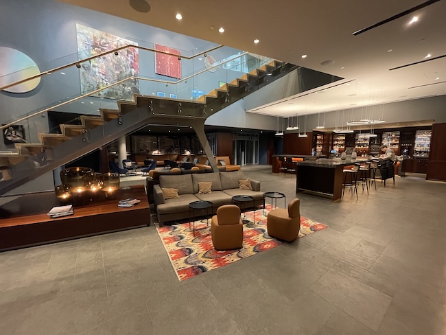 a room with a staircase and a couch and chairs