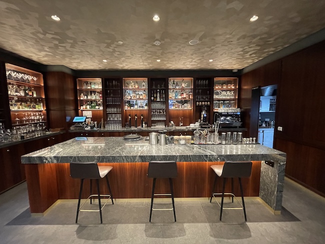 a bar with a counter and shelves of liquor