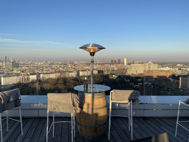 a table and chairs on a rooftop overlooking a city