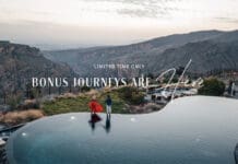 a man and woman standing on a pool with a view of mountains