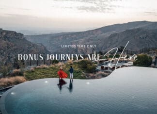 a man and woman standing on a pool with a view of mountains